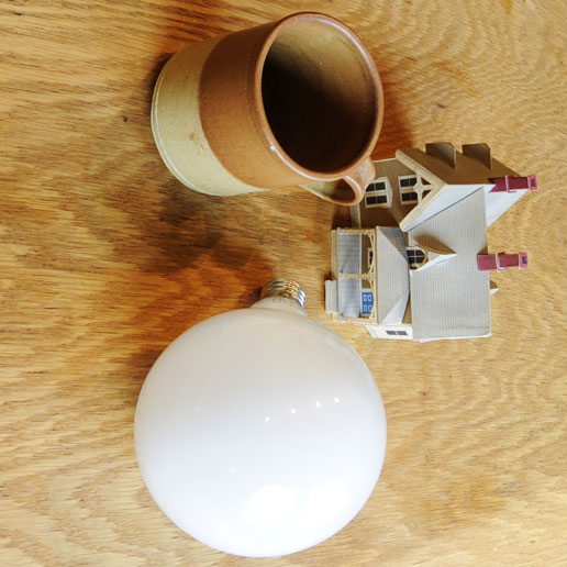 An unusual view of lightbulb-mug-house arises from LittleMan lying on his left side